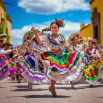 Women dancing in traditional Mexican dresses during Cinco de Mayo celebration in Puebla – cultural festival featured on EternalSlots.com casino blog.