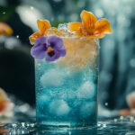 Vibrant blue summer mocktail garnished with edible flowers and crushed ice, perfect alcohol-free drink for 2025 featured on EternalSlots.com