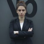 Confident woman in a black blazer standing with arms crossed symbolizing self-respect, assertiveness, and the power of saying no.