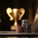 Online casino tournament concept with poker chips on laptop and trophy in background.