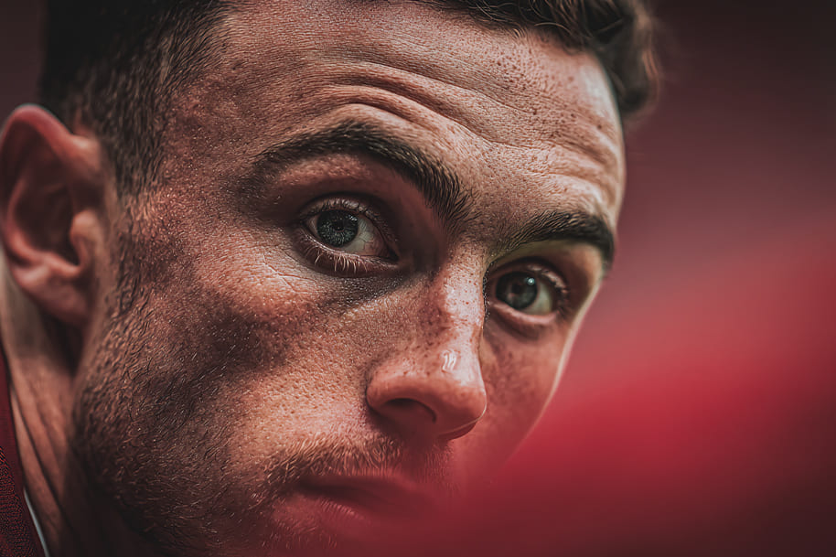 Close-up of Diogo Jota looking intensely focused before a match, showcasing his determination and passion for football.