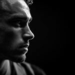 Black and white profile of Diogo Jota in deep thought, highlighting his intense focus and legacy on the pitch.