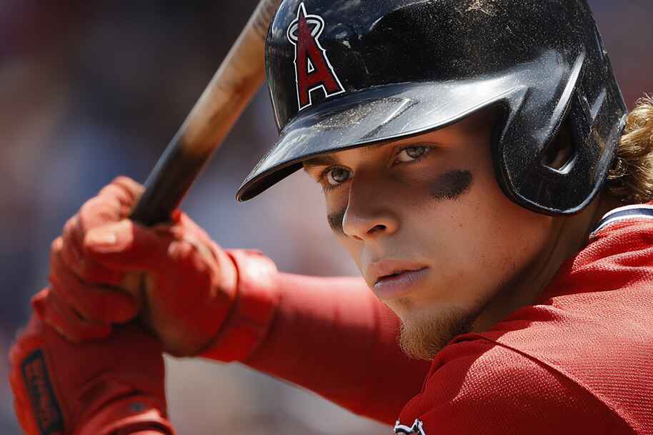 Intense close-up of a focused baseball batter in red uniform and helmet, ready to swing during a game.