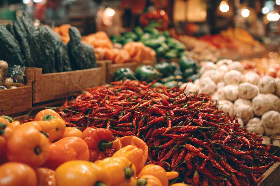 Colorful fresh peppers, mushrooms, and vegetables at farmers market – sustainable food trends and healthy eating in 2025
