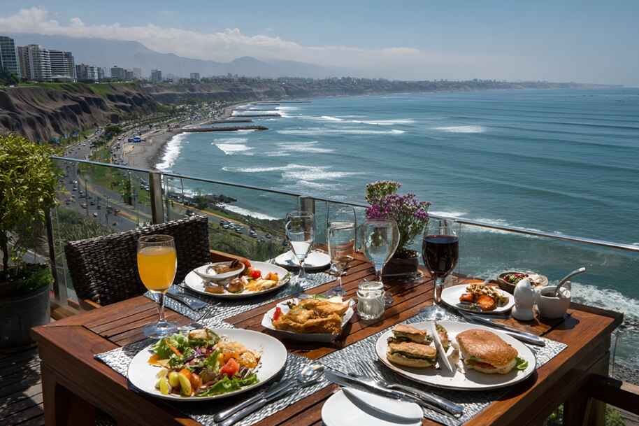 Scenic oceanfront lunch with Peruvian dishes overlooking Lima coastline – top foodie travel destinations in South America