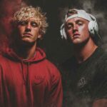Two confident American influencers in streetwear and headphones posing in a dark, smoky setting — representing the bold lifestyle of digital millionaires featured on EternalSlots.com blog.
