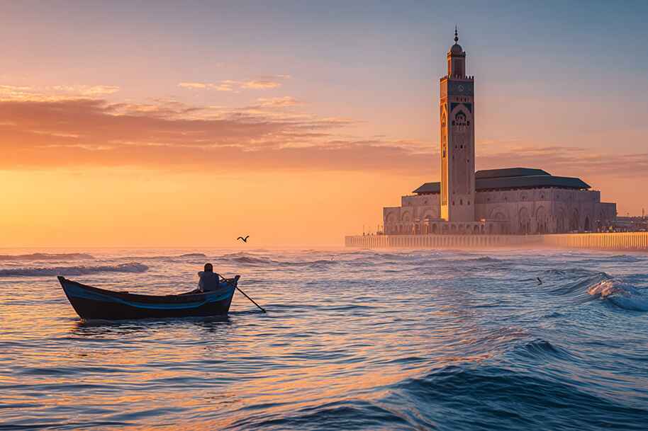 Peaceful morning view of fisherman near Hassan II Mosque in Casablanca, Morocco, top spiritual and coastal destination for 2025