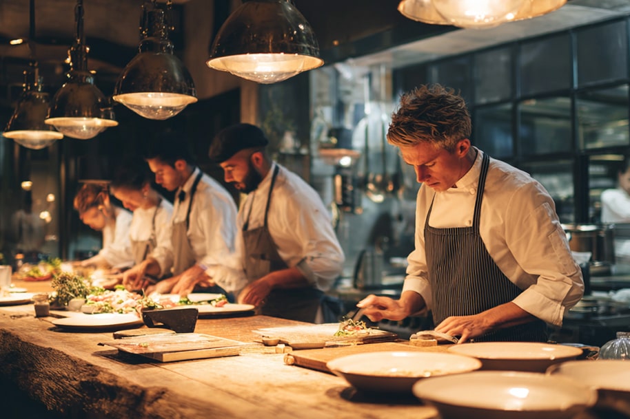 Team of chefs preparing gourmet meals in a high-end restaurant – collaborative cooking and innovation in the future culinary industry.