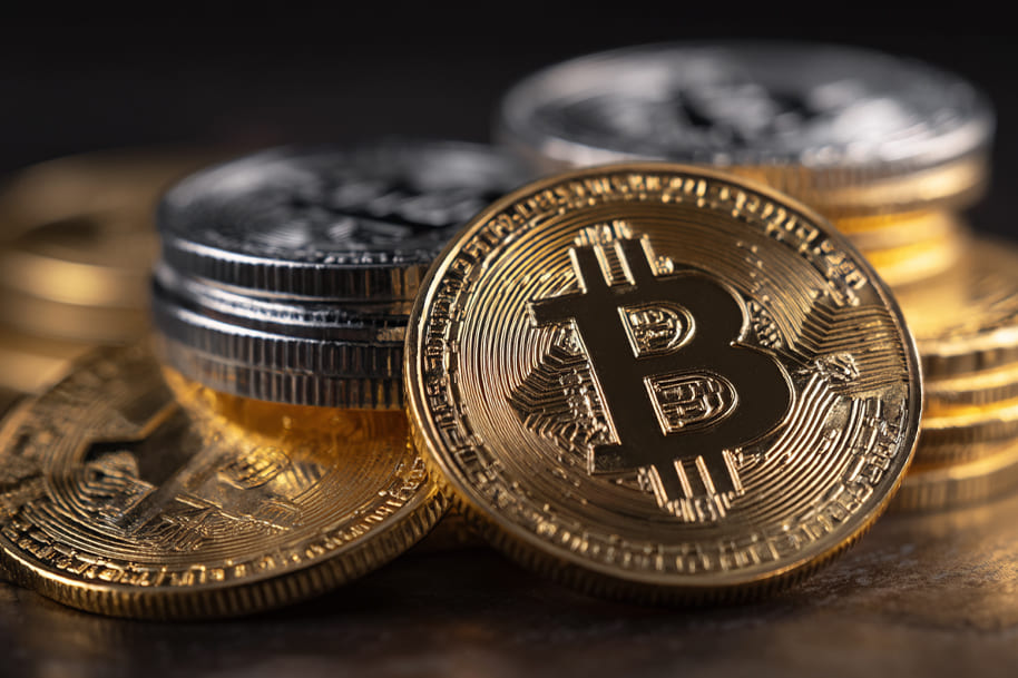 Stacks of gold and silver Bitcoin coins representing the wealth of Bitcoin creator Satoshi Nakamoto.