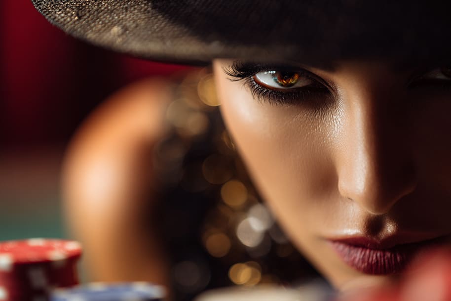 Intense close-up of mysterious woman at casino table – unlock your mystery bonus with an exclusive casino offer.