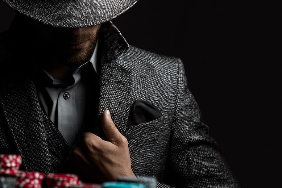 Mysterious man in suit with poker chips – unlock your mystery bonus with this exclusive casino offer.