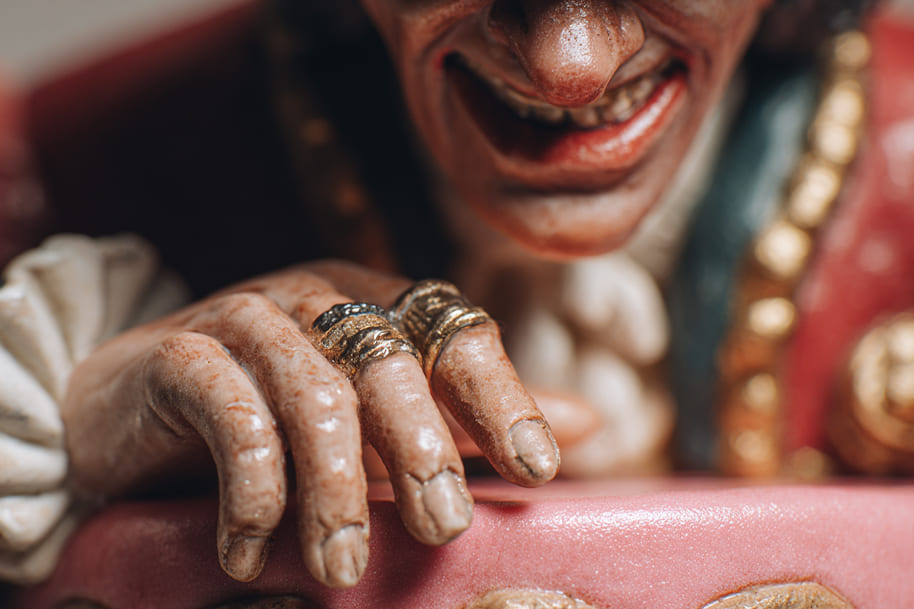 Close-up of a vintage figurine with a mischievous grin and ornate rings, reflecting the eccentric charm of obscure U.S. holidays.
