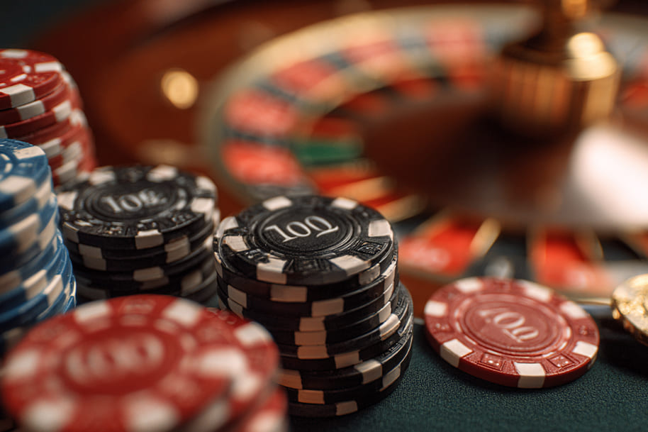 Stacks of colorful red, black, and gold casino chips symbolizing deposit bonuses vs cashback offers at Eternal Slots online casino.