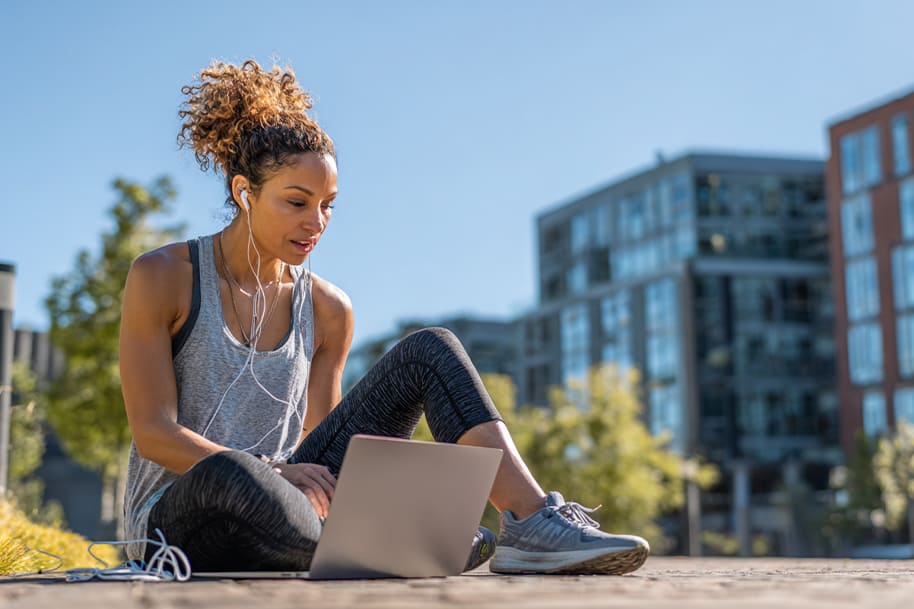 Active remote worker using laptop outdoors in workout gear – embracing work-from-home wellness and fitness in a flexible digital lifestyle