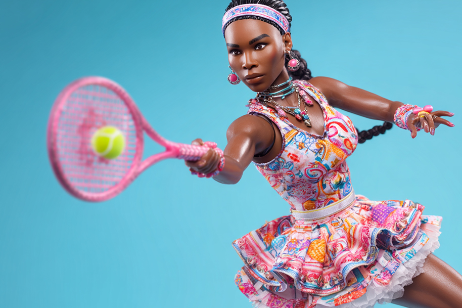 A Venus Williams Barbie doll in a colorful tennis dress mid-swing with a pink racket, ready to hit a tennis ball, showcasing action and energy.