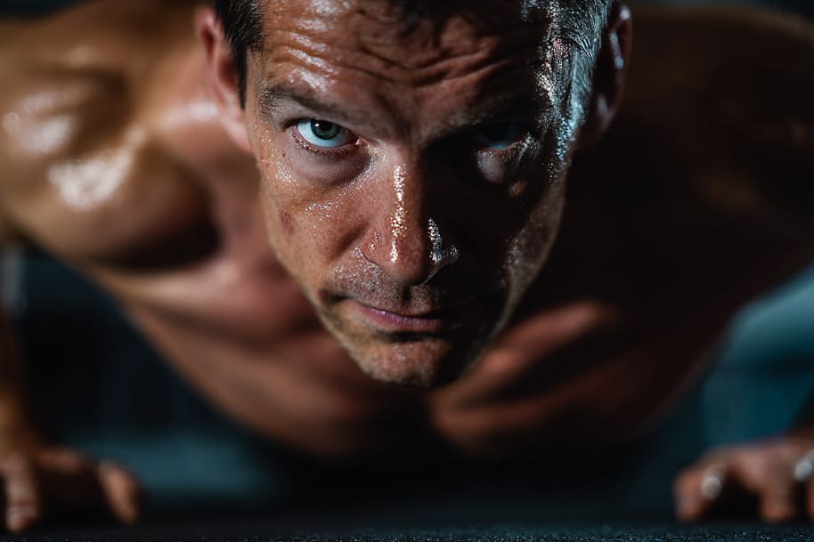Man doing push-ups at home during intense workout routine, focusing on strength and endurance training