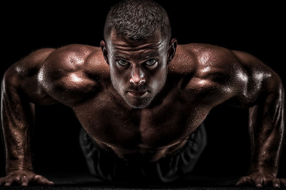 Focused man doing push-ups during intense home workout routine, building strength and endurance with bodyweight exercises