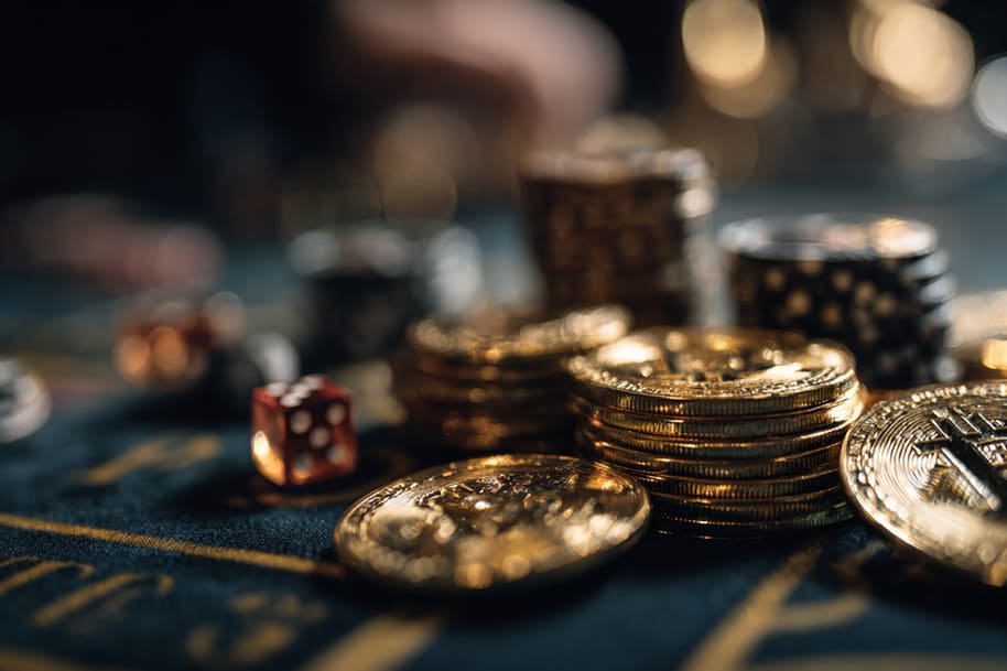 Stacks of golden Bitcoin coins and red dice on a casino table, representing crypto casino promotions and exclusive player rewards.