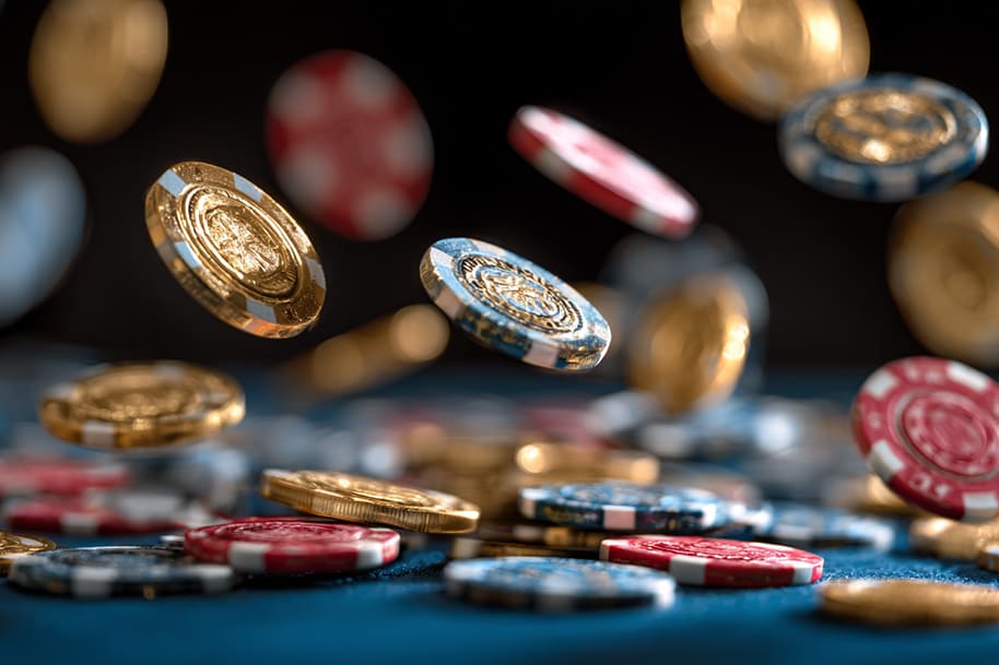 Gold and red casino chips dropping on a table illustrating the benefits of low wagering bonuses in online casinos.