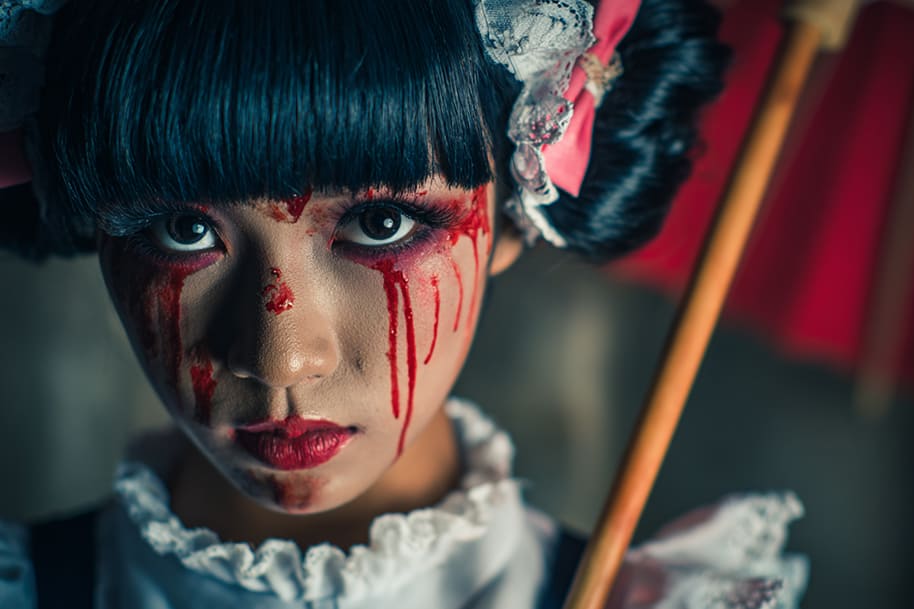 Close-up of a person wearing dramatic Halloween makeup with blood-red tears and gothic accessories, showcasing bold and trending Halloween costume ideas for 2025 on Eternal Slots Casino’s Halloween blog.
