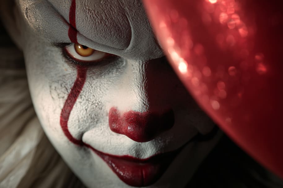 Scary clown character with red balloon and menacing smile, representing a horror movie villain in a Halloween-themed dating profile concept.