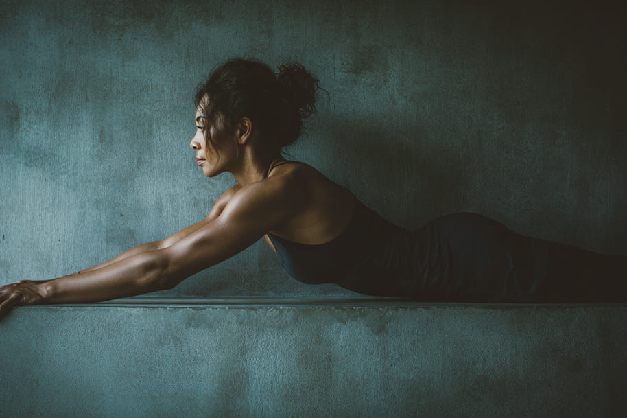 Focused woman doing wall Pilates exercise in a calm, minimalist space, emphasizing body awareness and mindful fitness training.